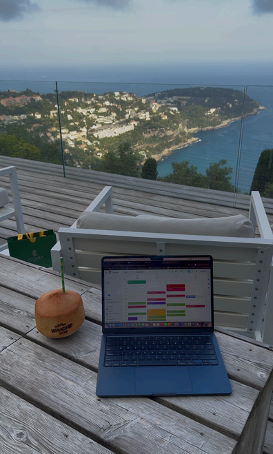 Laptop with a full calendar on a deck overlooking the sea